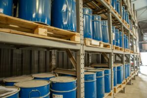 Warehouse with blue industrial metal barrels for safe storage of drums and IBCs
