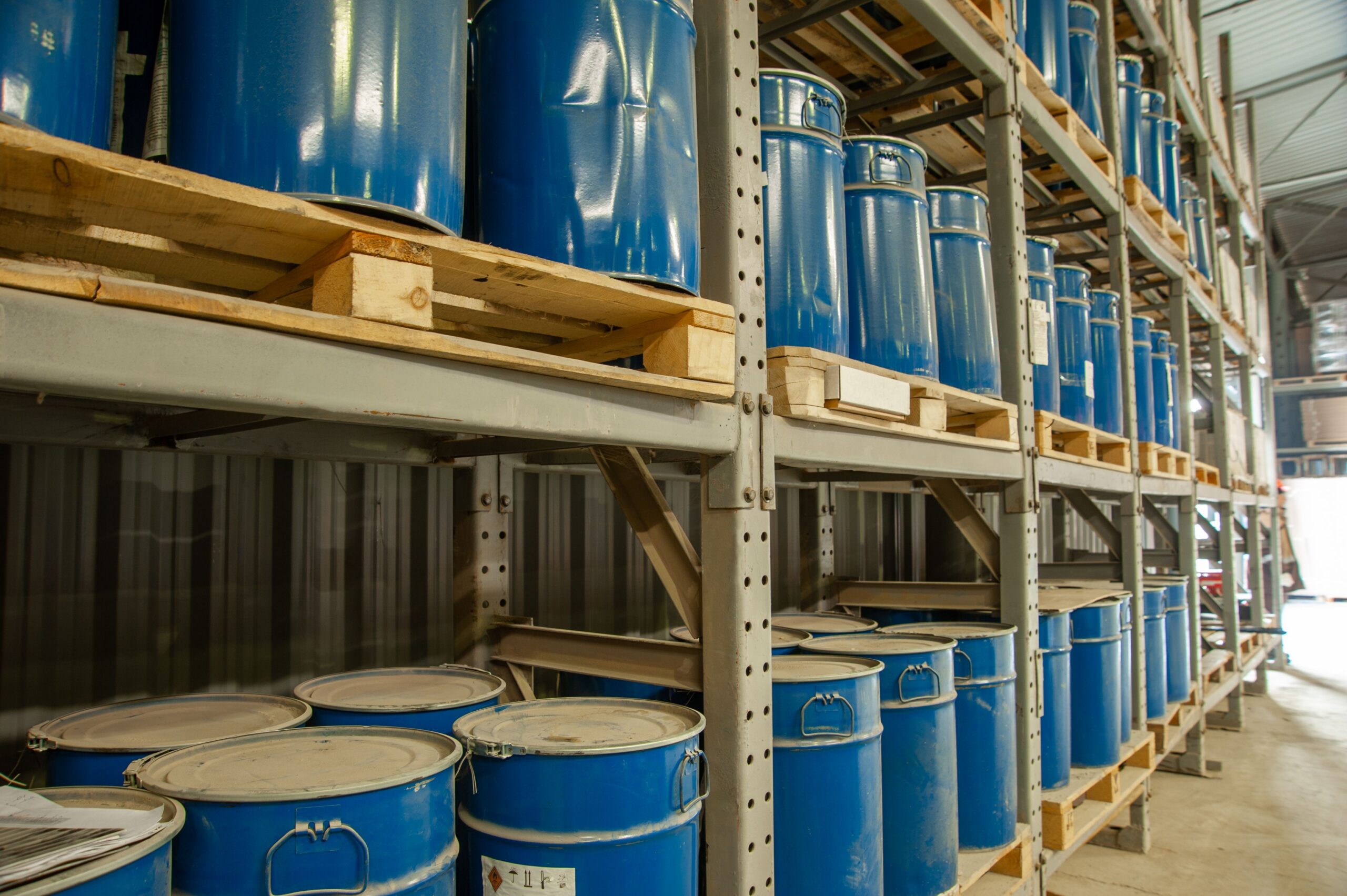 Warehouse with blue industrial metal barrels for safe storage of drums and IBCs