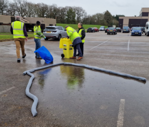 Spill response training session demonstrating the use of Absorbent Granules and spill control materials in a workplace environment.